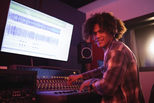 Portrait of male audio engineer using sound mixer