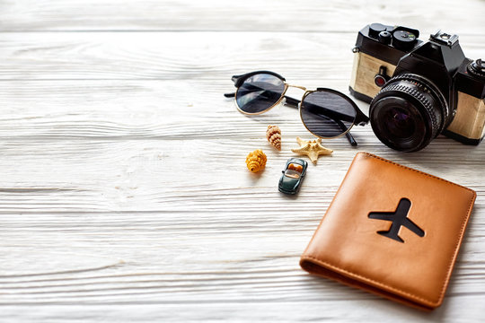 travel and wanderlust concept, summer vacation background, space for text. photo camera sunglasses passport  car shells on white wooden table. planning summer holiday