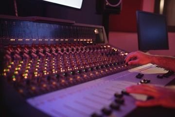 Hands of male audio engineer using sound mixer
