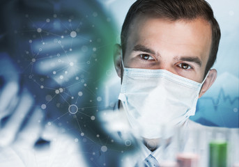 Young scientist mixing reagents in glass flask in clinical laboratory