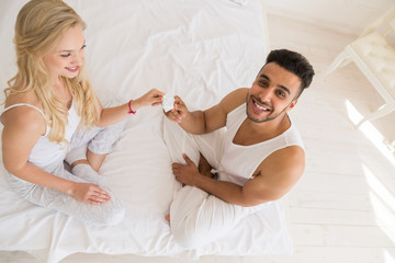 Young Couple Sitting In Bed, Smiling Woman Man Hold Condom Man Lovers Contraception Protection Bedroom Top Angle View