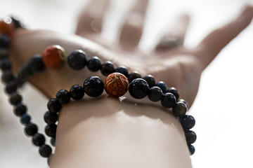 Woman's hand with a mala bracelet  - 145781224