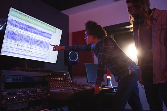 Male audio engineers using sound mixer
