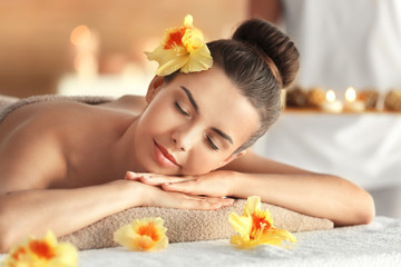 Beautiful woman lying on massage table in spa salon