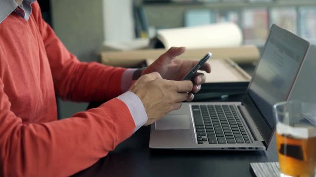 Businessman hands using smartphone by table in the office, 4K
