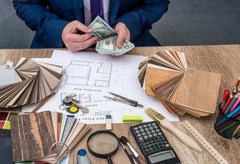 Designer counts the money for the work - house project.
