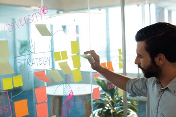 Businessman analyzing adhesive notes at office