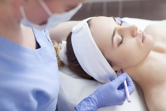 Young beautiful woman in the beauty salon on the face treatment