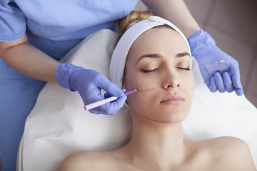 Young beautiful woman in the beauty salon on the face treatment