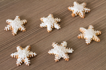 Fototapeta na wymiar Gingerbread snowflake on wood background. Aerial view.