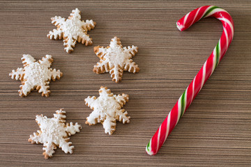 Gingerbread snowflake and lollipop on dark wood background. Aerial view. 