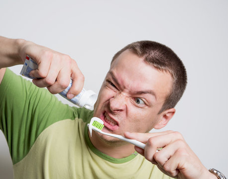 Man Squeezing Toothpaste On The Brush