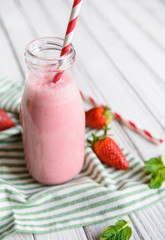 Refreshing strawberry milkshake in a glass bottle