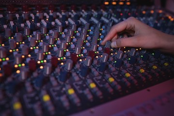 Hands of female audio engineer using sound mixer