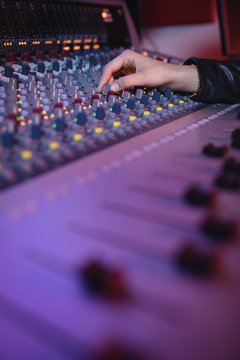 Hands of female audio engineer using sound mixer