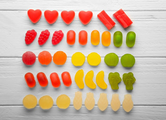 Composition of colorful jelly candies on light wooden background