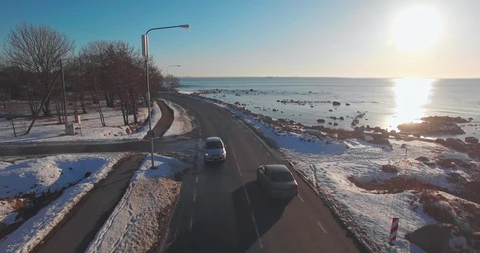 Aerial photography of wagons along a city road on the Baltic beach with a beautiful sunset