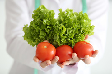 Young female nutritionist standing with vegetables, closeup