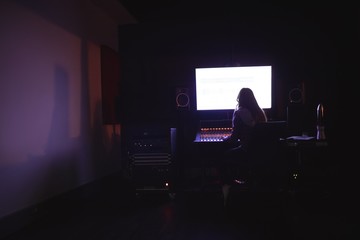 Female audio engineer using sound mixer