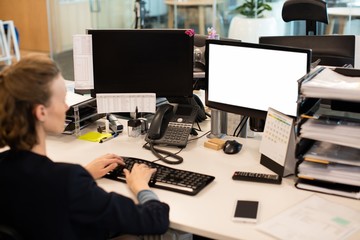 Businesswoman working on desktop pc at office