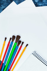 Paper, watercolor paints,  brushes for painting, top view, copy space