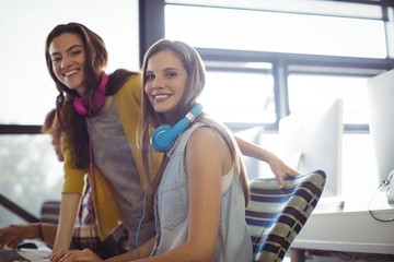 Female sound engineer and colleagues working in office