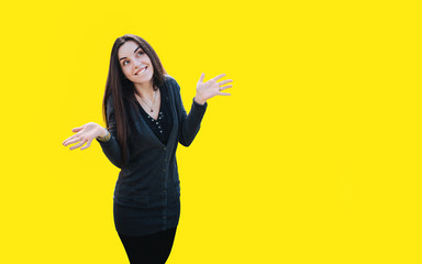 Young woman smiling and spreading her arms in both directions isolated on yellow background