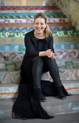 Beautiful woman is sitting on a stairs