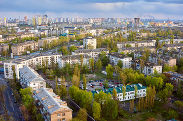 Fototapeta premium The aerial View of urban residential district in Kyiv,Ukraine in spring.View over the city rooftops with sunlight at Darnitsa suburb.Moderns buildings at Industrial uptown;residential neighbourhood.