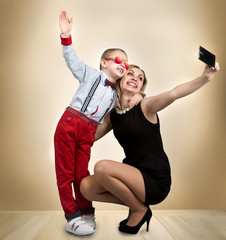 Young mother and son are photographed on a mobile phone ,making selfie .Stylish,trendy,modern