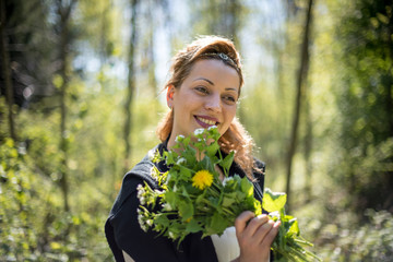 Portrait of young woman smelling bouquet of flowers