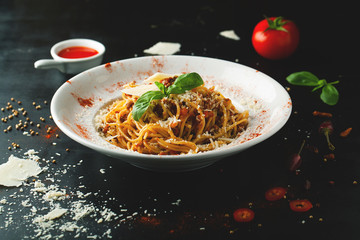 Delicious pasta of Bolognese with Parmesan and basil in a plate