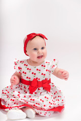 Little girl in white with a red dress with a bow on her head