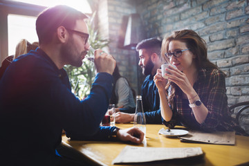 Colleagues from work socializing in restaurant and eating together