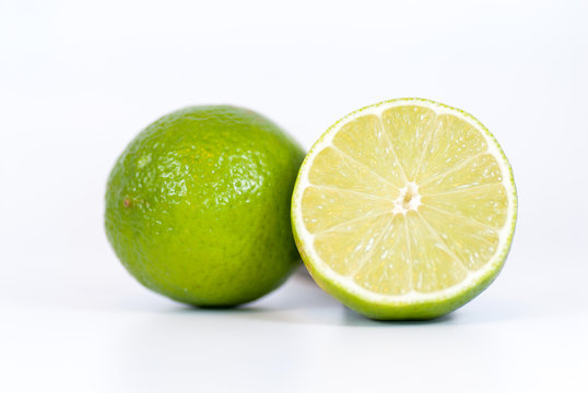 half lime and whole lime over white background with copy space