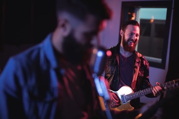 Musician playing electronic guitar in studio