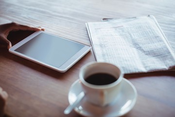 Hand of woman using digital tablet while having coffee