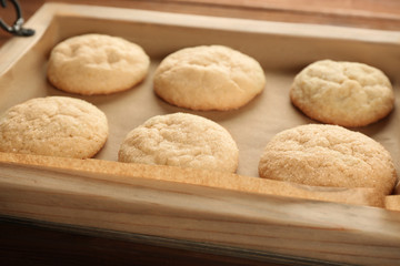 Tasty sugar cookies on wooden tray, closeup