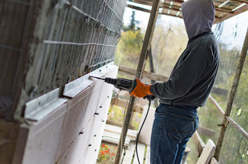 Fototapeta premium The process of drilling holes in the concrete wall