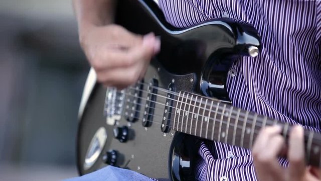 men hands guitarist playing guitar outdoor. close-up