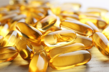 Fish oil capsules on wooden table