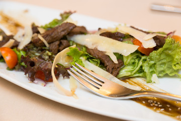 Salad greens and meat on a white plate. Healthy Eating