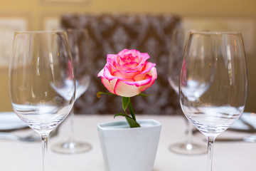 Pink rose in a vase as table decoration. Table setting