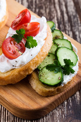 Sandwiches with cream cheese, cucumbers and tomatoes