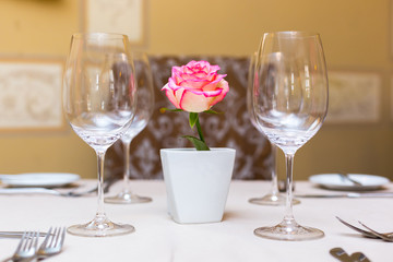 Pink rose in a vase as table decoration. Table setting
