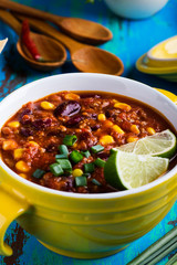 Chili con carne stew served in yellow bowl