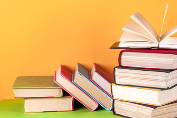 Open book, hardback books on bright colorful background.
