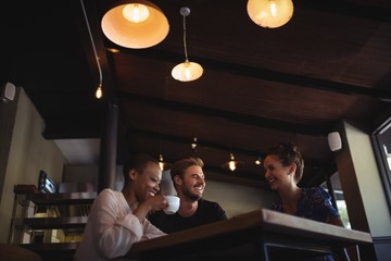 Happy friends interacting while having coffee
