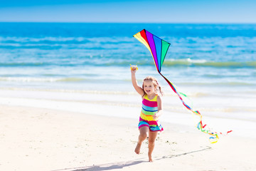 Child flying kite on tropical beach