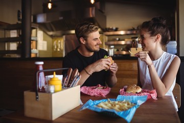 Happy couple interacting while fast food - Powered by Adobe